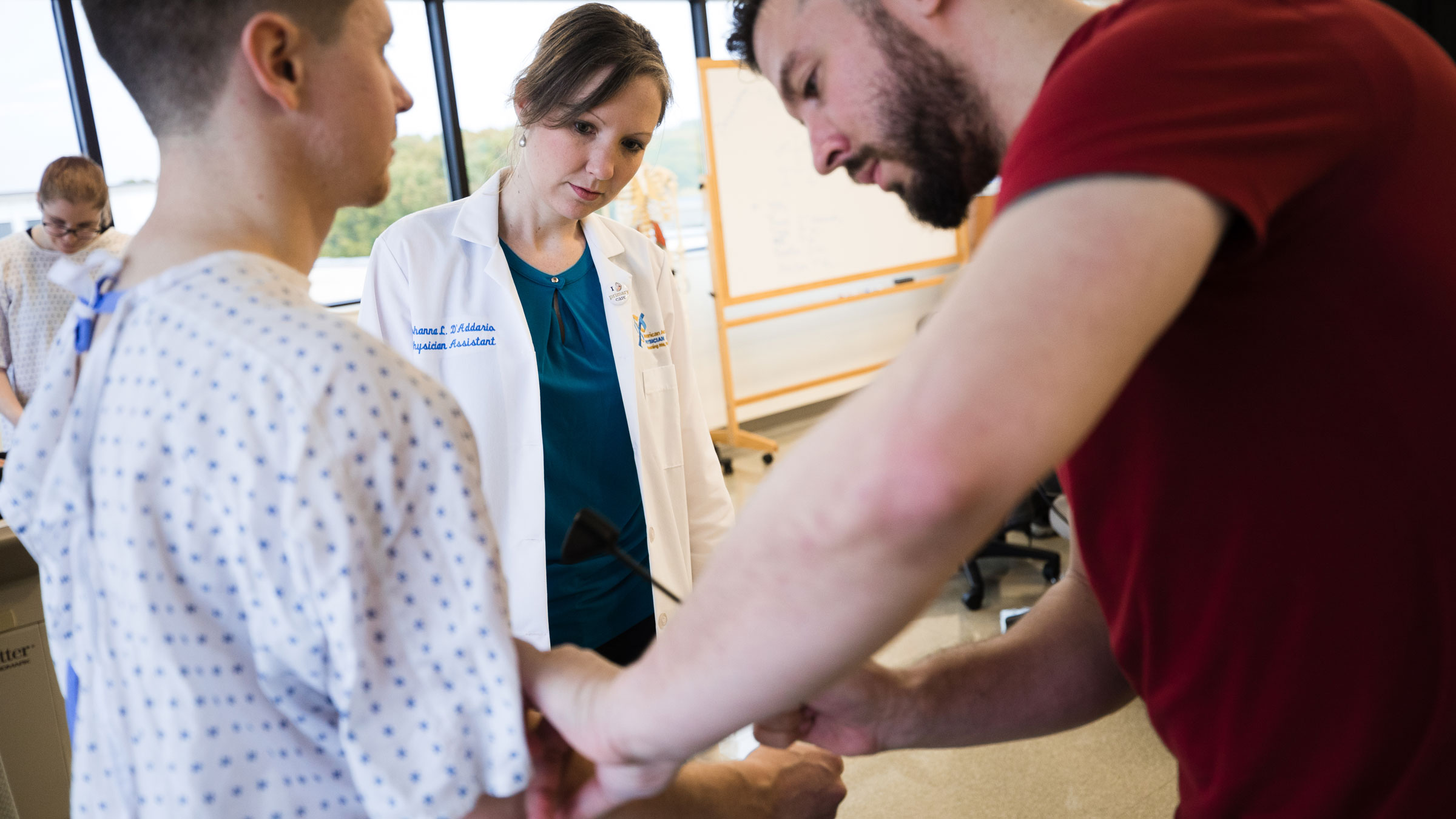 Quinnipiac Physician Assistant Students during their Physical Diagnosis Lab (Left to Right: Walker Hinson, Prof. Johanna D'Addario, Benjamin Lapaluccio), on October 30, 2017, on the North Haven Campus.), on October 30, 2017, on the North Haven Campus.